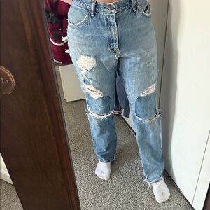 Distressed Blue Women's Jeans with booty peaking out.